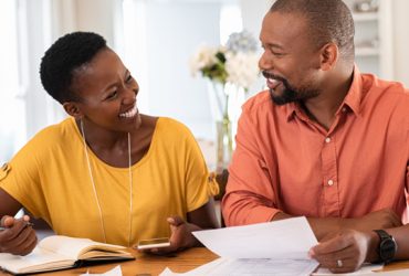 Couple smiling while planning and budgeting
