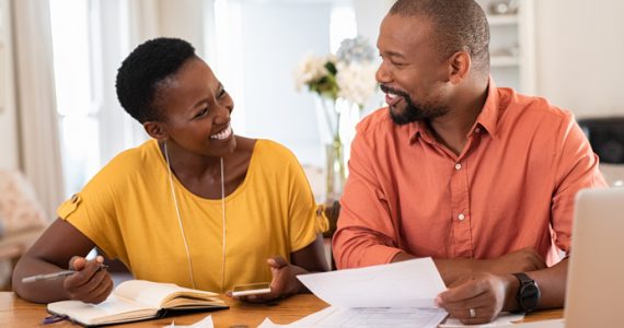 Couple smiling while planning and budgeting