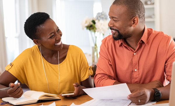 Couple smiling while planning and budgeting